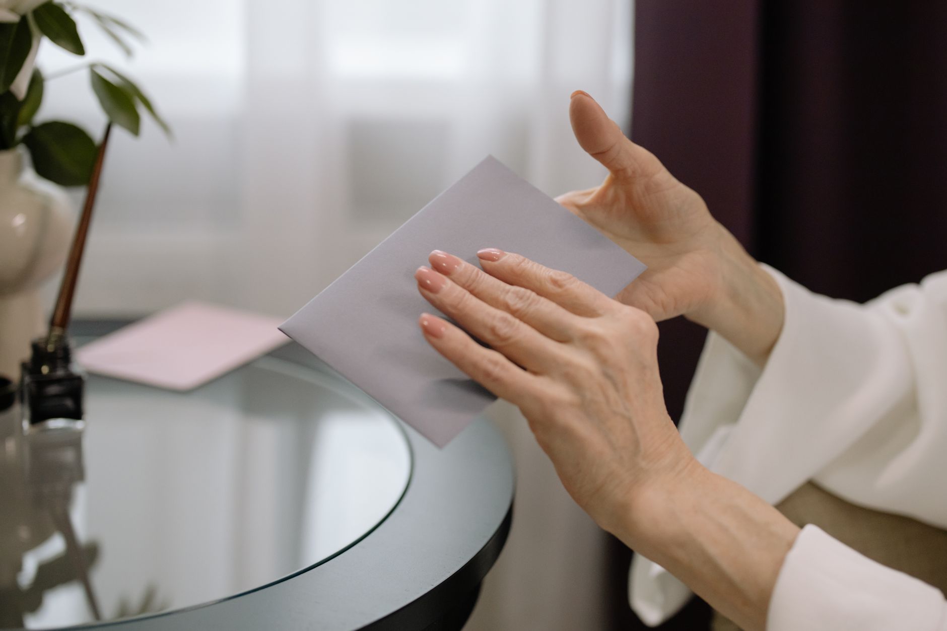 Person holding an unopened letter at a table